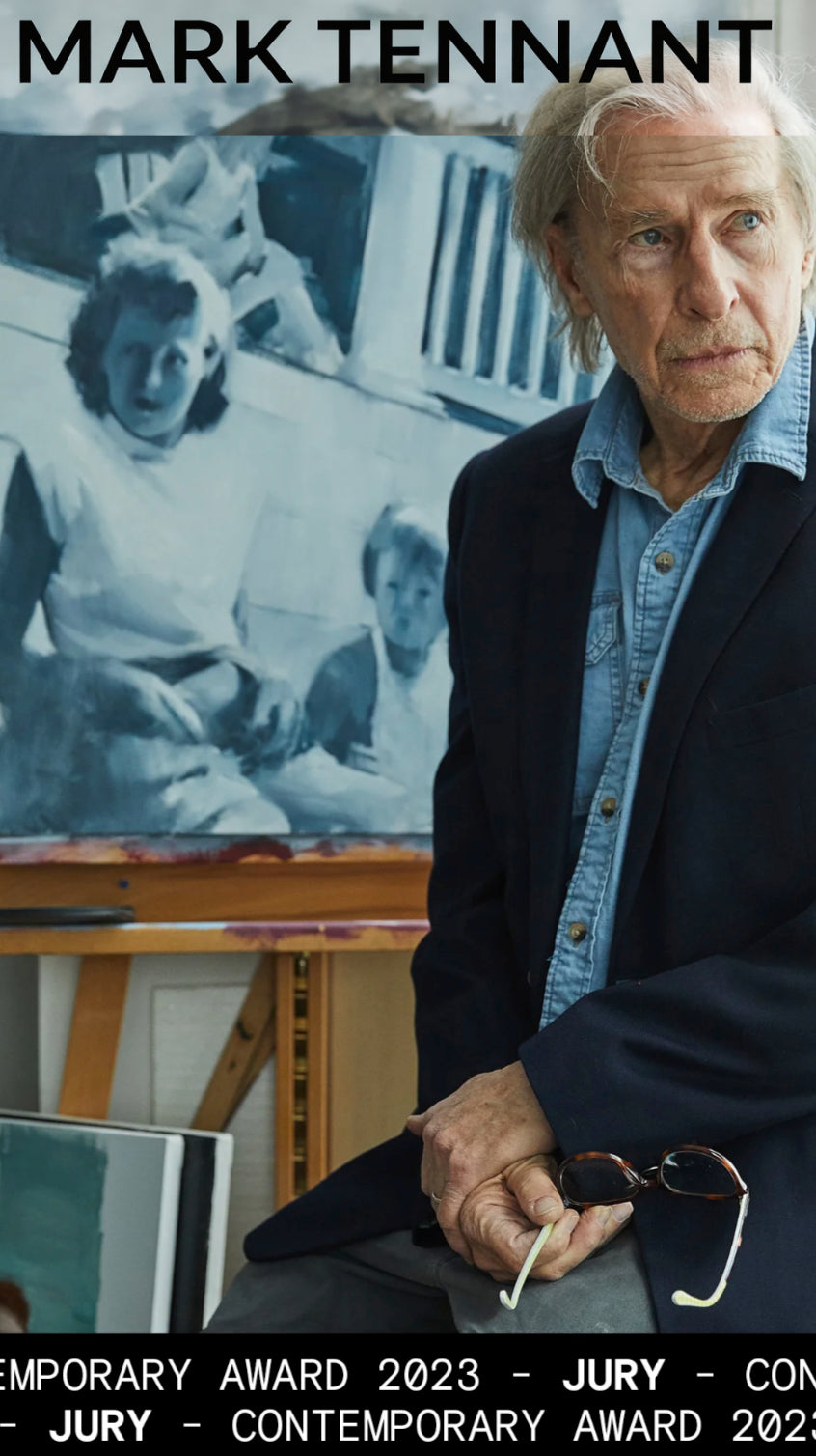 Mark Tennant  standing in front of a painting with text about a contemporary award.